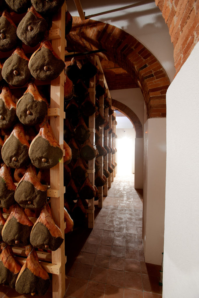 Tuscan ham hanging wooden shelves in Radda in Chianti